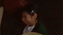 a woman in a green sweater is sitting in a chair with a hat on .