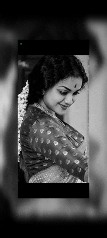 it is a black and white photo of a woman in a saree .