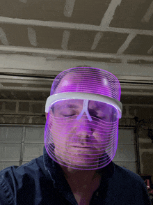 a man is wearing a purple light mask on his face