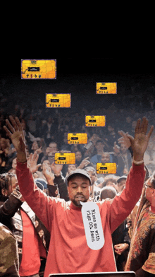 a man in a red shirt holds up his hands in a crowd of people