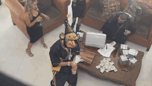 a man wearing a monkey mask is standing in front of a table full of money