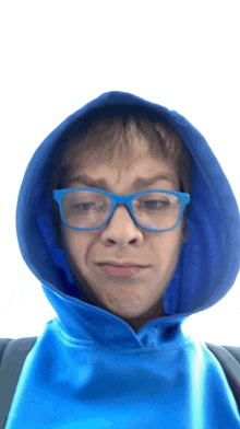 a young boy wearing glasses and a blue hoodie makes a funny face