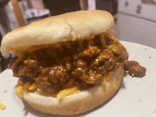 a sandwich with chili and cheese on a bun on a plate