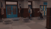 a group of people jumping on trampolines in a school hallway