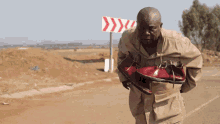 a man is carrying a pair of shoes in front of a sign that says ' y ' on it