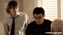 two men are standing next to each other in front of a window with make a gif.com at the bottom of the screen