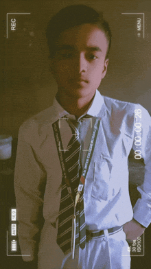 a young man in a white shirt and tie with a lanyard that says ' s.p. veer college ' on it