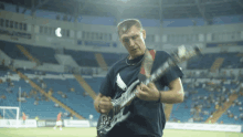 a man playing a guitar in a stadium with a sign that says ' nsc ' on it