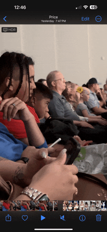 a phone screen shows a photo of people sitting in a room with the time 12:46