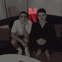 two young men sitting on a couch with a netflix logo in the corner