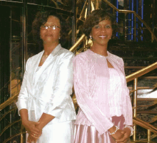 two women standing next to each other on a staircase