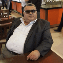 a man wearing sunglasses is sitting at a table