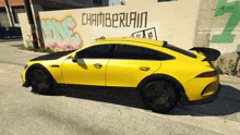 a yellow car is parked in front of a wall that has the word chamberlain on it