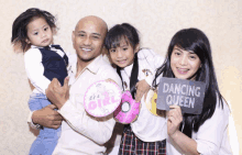 a family posing for a picture with a sign that says " dancing queen "