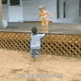 a boy and a girl are playing in the sand and the boy is holding the girl 's hand .