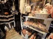 a woman in a black dress is standing in a store with a basket of stuffed animals on a shelf