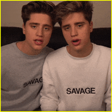 two boys wearing sweatshirts that say savage on them