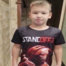 a young boy wearing a black t-shirt with a picture of a soldier on it .