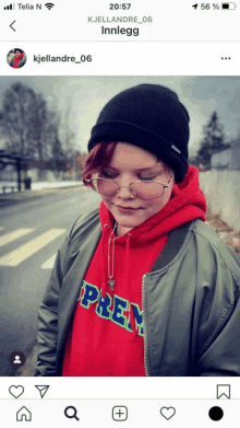 a person wearing a red supreme hoodie and a black hat