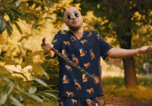 a man wearing a shirt with foxes on it holds a cane