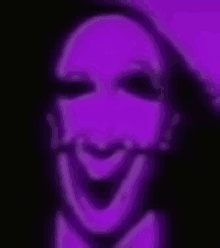 a close up of a person 's face with a purple background and a purple smile .