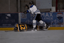 a hockey game is being played in front of an ad for remax lence