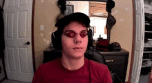 a man wearing red glasses and headphones is looking at the camera