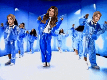 a group of people are dancing in a room with blue walls