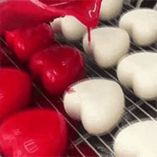 a bunch of red and white hearts are sitting on top of a cooling rack .