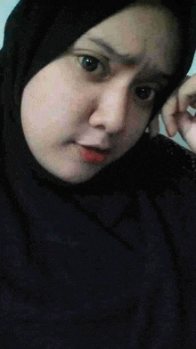 a close up of a woman wearing a hijab