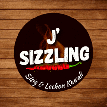 a logo for j 's sizzling sits on a wooden surface