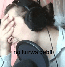 a person wearing headphones covering their face with their hand and the words no kurwa debil on the bottom right
