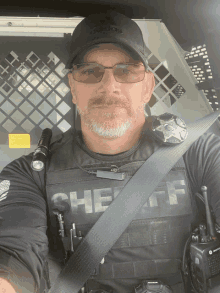 a man in a sheriff uniform is sitting in a cage