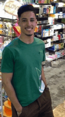 a man wearing a green shirt is standing in front of a sign that says love