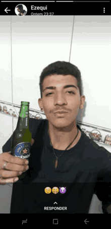 a young man is holding a bottle of heineken