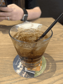 a martini glass with a straw on a coaster that says mcdonald 's