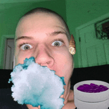 a man with a cigarette in his mouth and a bowl of purple liquid