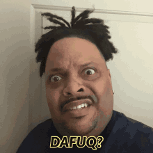 a man with dreadlocks is making a funny face and has the word dafuq on his shirt