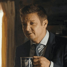 a man in a suit and tie is holding a coffee cup