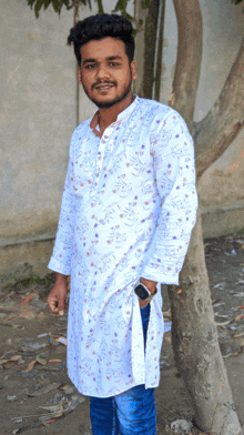 a young man wearing a white shirt with purple flowers on it