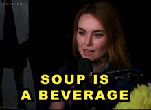 a woman is talking into a microphone with the words soup is a beverage behind her