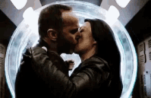 a man and a woman are kissing in front of a glowing circle .