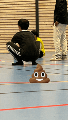 a group of people squatting on the floor with a picture of a poop with a smiling face