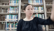 a woman stands in front of a bookshelf with a book titled " a brief history of the world "