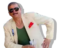 a man wearing sunglasses and a white jacket holds a drink