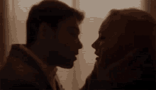 a man and a woman are kissing in a dark room .