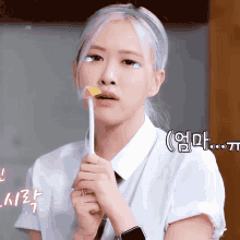 a woman with white hair is holding a lollipop in her hand .