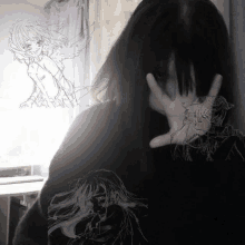 a girl covering her face with her hand with a drawing of a girl behind her