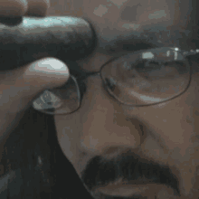 a man wearing glasses is smoking a cigar on his forehead