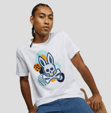 a man wearing a white t-shirt with a skull and crossbones bunny on it